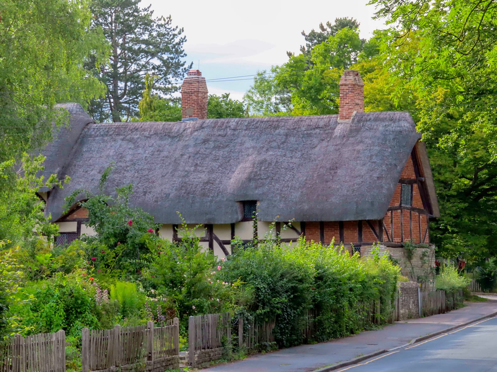 The thatched roof and flower garden of Anne Hathaway's Cottage in Shottery
